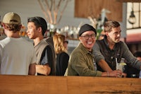 a group of people standing at a bar