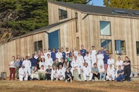 a group of people posing in front of a house